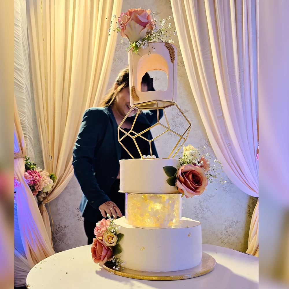 Multi-tier wedding cake with a suspended gold geometric tier